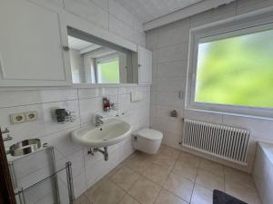 a bathroom with a sink and a toilet and a window at Karawankenblick in Villach +56 photos