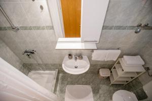 a bathroom with a sink and a toilet and a mirror at Apartmani Mery in Rab +25 photos