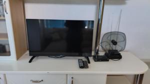 a television sitting on top of a white cabinet at Apartmani Ribar in Ohrid +26 photos