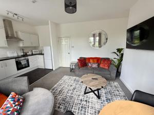 a living room with a couch and a table at City Centre Embankment Apartments Superb Location in Cardiff +23 photos