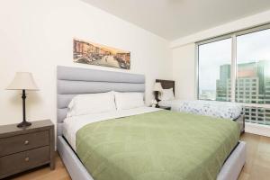 una camera da letto con due letti e una grande finestra di Snug 3BR HighRise with Pool, Spa & Rooftop Views a Los Angeles Altre 34 foto