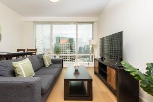 un soggiorno con un divano e una TV di Snug 3BR HighRise with Pool, Spa & Rooftop Views a Los Angeles