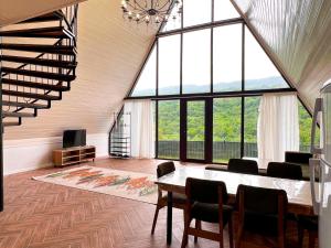 a large room with a table and chairs and windows at Quba Harmoniya in Quba