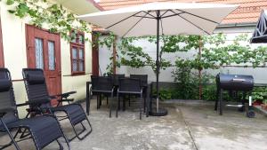 Un patio con una mesa y sillas y una sombrilla. en Casa Gruia, en Ocna Sibiului