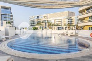an image of a swimming pool in front of a building at Bloomfields Elegant 1BR Ajwan Soul Beach Access in Abu Dhabi