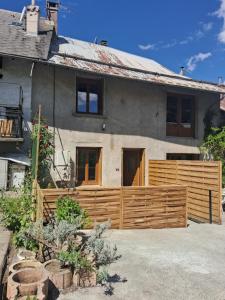 a house with a wooden fence in front of it at Le "46" jusqu'à 6 personnes in Crots