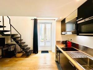eine kleine Küche mit einer Treppe, die zu einem Fenster führt in der Unterkunft LE LAVADIÈRE - Joli duplex avec terrasse in Sèvres + 10 Fotos