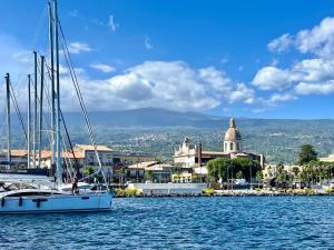 a boat in the water in front of a city at Dimora degli Affreschi in Riposto