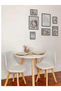 a table with two white chairs and a white wall at Buenos Aires pleno centro, a pasos del Obelisco in Buenos Aires