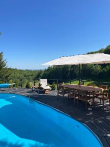 a swimming pool with a picnic table and an umbrella at Naturalna Cisza in Michałkowa