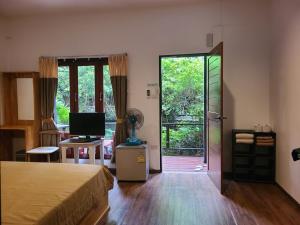 a bedroom with a bed and a sliding glass door at Cozy house by the sea in Ko Phangan