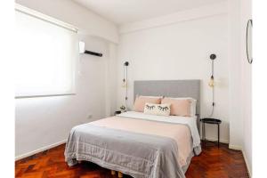a white bedroom with a large bed with pink pillows at Buenos Aires pleno centro, a pasos del Obelisco in Buenos Aires