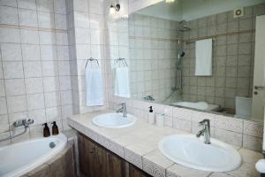 a bathroom with two sinks and a tub and a mirror at Viewpoint apartment chalkis in Chalkida +29 photos