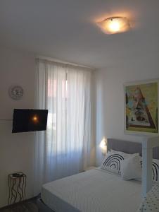 Un dormitorio blanco con una cama y una ventana. en Covenate House, en Como