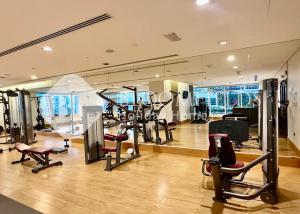 Un gimnasio con cintas de correr y equipos de ejercicio en un edificio. en Bloomfields Grandeur 1BR In Lamar Raha, en Abu Dabi