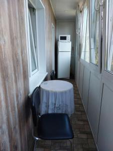 a table and chairs in a room with a refrigerator at Квартира с 2-мя СПАЛЬНЯМИ, ЦЕНТР Проспект Центральный-3-я Слободская in Mykolaiv