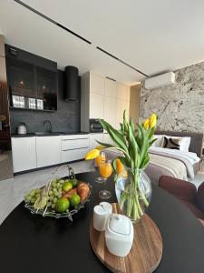 una cocina con mesa y un bol de fruta en Chronos Luxury Apartments, en Varsovia
