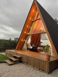 a frame house with a deck and a window at Chalé amanhecer Serra do Rio do Rastro in Louro Müller
