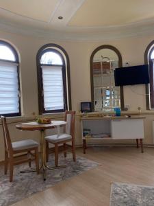 ein Wohnzimmer mit Tisch und Stühlen und zwei Fenstern in der Unterkunft Studio Carobna Dunja in Banja Koviljača + 7 Fotos