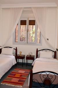 two beds in a room with two windows at Seaside 2 Bedrooms Villa - IMI OUADDAR in Agadir