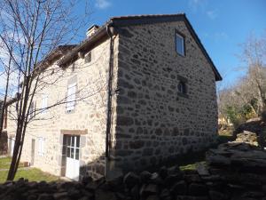 una antigua casa de piedra con una pared de piedra en Le Relais de Garabit, en Anglards-de-Saint-Flour