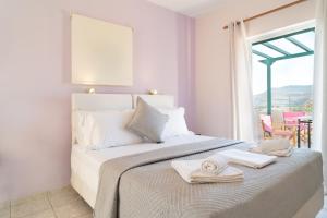 a white bedroom with a bed with towels on it at Vasiliki Studios in Petra