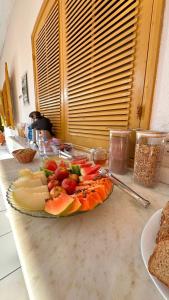 a plate of food on a counter with fruit on it at Pousada Vieira in Paraty +68 photos