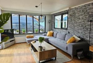 a living room with a couch and a brick wall at Chalet Rustiek in Anloo