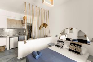 a bedroom with a large white bed with a large mirror at Santanna White Houses in Parikia