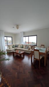 un soggiorno con divano, tavoli e finestre di Achada de Gaula House a Gaula