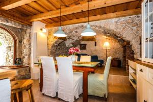 GrižaneにあるVilla Toscana - Charming stone Villa with private pool & gardenのテーブルと椅子のあるキッチンとダイニングルーム