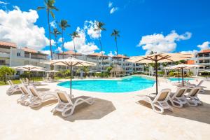 a swimming pool with lounge chairs and umbrellas at STANZA MARE 1 Br,2Br,3Br APARTAMENT ON THE BEACH in Punta Cana