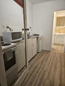 a kitchen with a stove top oven next to a counter at Park Lodge Motel in Te Awamutu