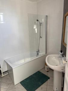 ein weißes Badezimmer mit Badewanne und Waschbecken in der Unterkunft Séjour à Paris in Aubervilliers + 4 Fotos