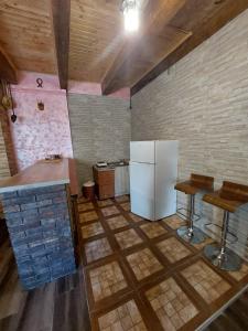 La cuisine est équipée d'un réfrigérateur et de deux tabourets de bar. dans l'établissement Village FLOWER IVY Montenegro, à Nikšić 11 autres photos