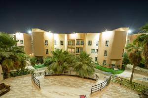 a large building with palm trees in front of it at Luxury Three bedroom Apt Al Yasmin in Riyadh