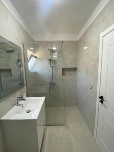 a white bathroom with a sink and a shower at Villa Oliver in Hamallë