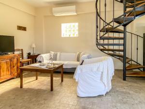 a living room with a couch and a spiral staircase at Kyparissis Beach house 1 in Lésvos