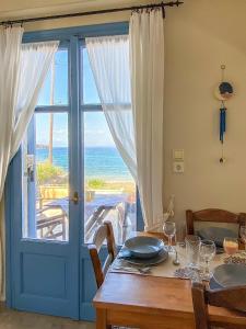 a dining room with a table with a view of the ocean at Kyparissis Beach house 1 in Lésvos