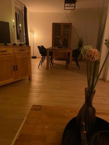 a living room with a table and a vase with flowers in it at FeWo Grote in Warburg