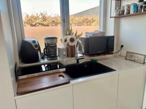 eine Küchentheke mit Spüle und Mikrowelle in der Unterkunft Spacious City Family Retreat With Garden & Patio in Odense + 87 Fotos