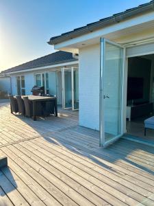 eine Terrasse mit Tisch und Stühlen auf einem Deck in der Unterkunft Spacious City Family Retreat With Garden & Patio in Odense