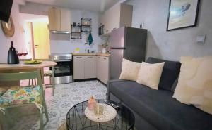 a living room with a couch and a kitchen at Lakkos House in Bendevís