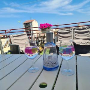 zwei Weingläser und eine Flasche auf dem Tisch in der Unterkunft Terrazza Fiumara in Letojanni + 9 Fotos