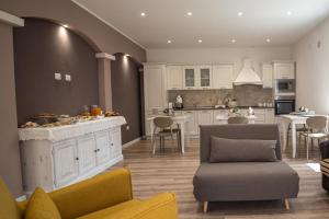 a kitchen and living room with a counter and chairs at Casa Midò in Muravera