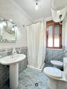 a bathroom with a sink and a toilet and a mirror at Four Seasons Beach Apartment Golem in Golem