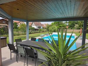 a patio with a table and chairs and a pool at Villa La Digue in Plobsheim
