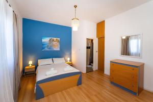 a bedroom with a bed and a blue wall at Apartmani Tinka in Starigrad