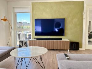 ein Wohnzimmer mit einem großen Flachbildfernseher in der Unterkunft Spacious City Family Retreat With Garden & Patio in Odense