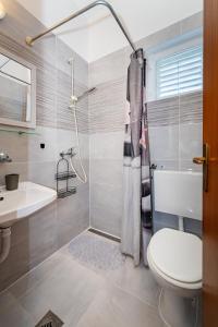 a bathroom with a toilet and a sink and a shower at Apartmani Tinka in Starigrad +103 photos